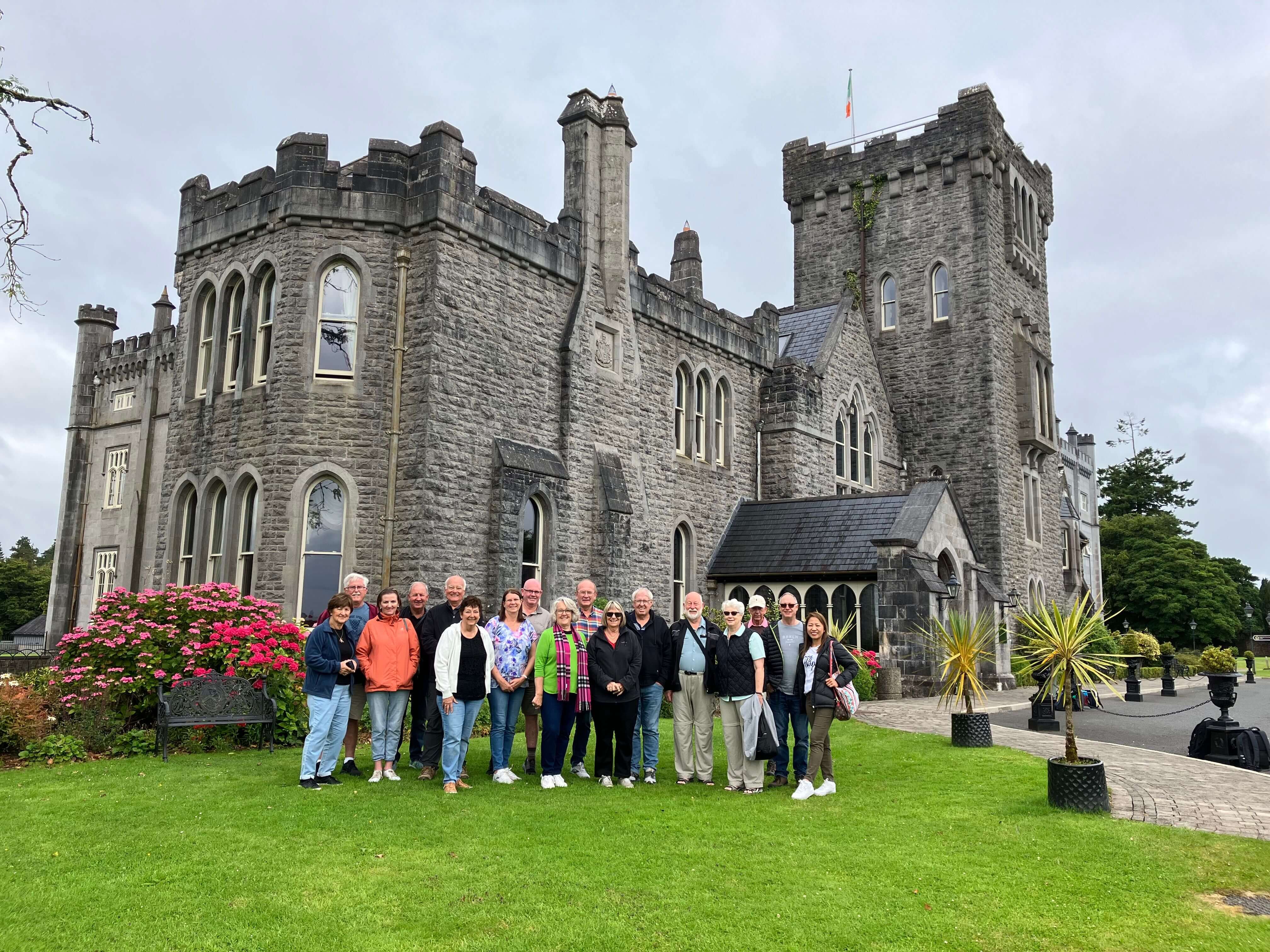 Group of mature adults standing together outside an Irish castle
