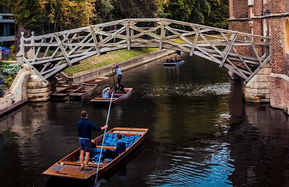 A pair of gondolas passing underneath the famous mathematical bridge in Cambridge.