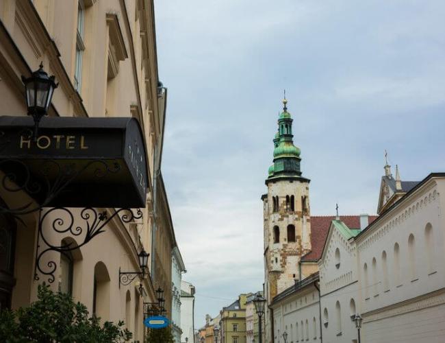 Kraków hotel entrance on the left of street view with church in background 