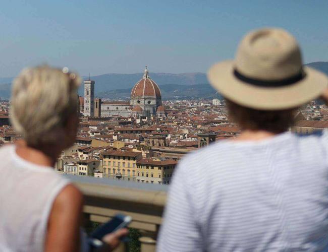 Man and woman overlooking the city of Florence with Florence Duomo in centre