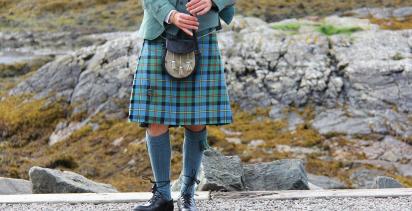 lower body of man in Highlander dress and kilt playing the bagpipes