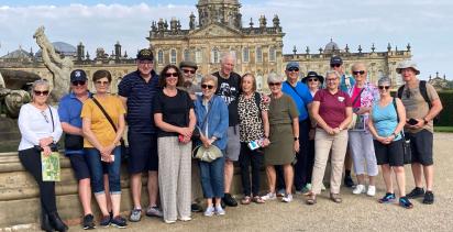 Group of mature adults standing together in front of British monument