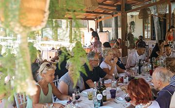 A tour group enjoying the food of Italy, eating outside.