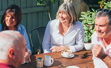 A group of travelers laughing together over a coffee break.