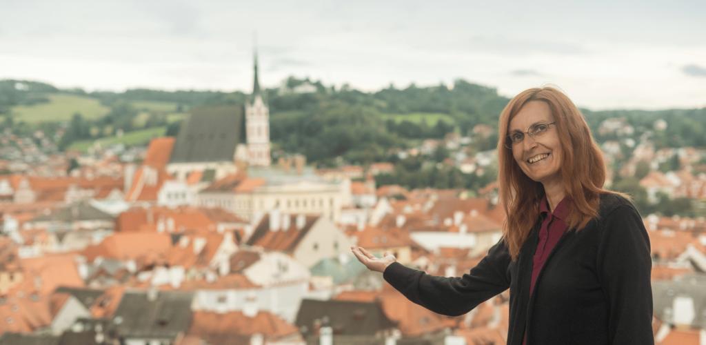 Tour Leader with open arms overlooking city
