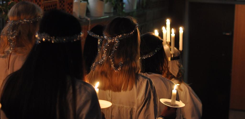 young teenagers carrying candles for St Lucia's Day celebrations