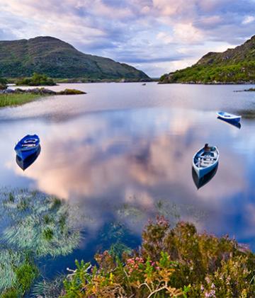 A view of a lake with a few paddle boats moored in Ireland's famous Killarney National Park.